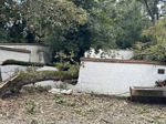 A wall heavily damaged by a tree after Hurricane Helene.